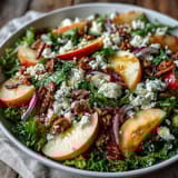 Fresh Mixed Greens and Apple Bowl tossed with walnuts, crumbled cheese, and a cider vinaigrette in a rustic bowl.