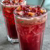 Vibrant mango dragonfruit refresher with bright pink hue and tropical fruit chunks, served over ice for a refreshing homemade Starbucks-inspired drink.