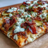 Tangy Pickle Pizza Flatbread with savory garlic ranch drizzle, ready to slice.