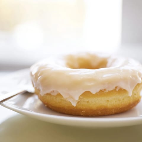 Golden-brown glazed yeast donuts, freshly fried and ready to be dipped, perfect dessert.