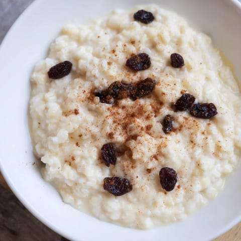 Creamy baked rice pudding, a comforting dessert with cinnamon and sweet raisins, perfect for sharing.