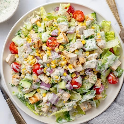 Ranch Chicken Chopped Salad in a white bowl, tossed in creamy Greek yogurt ranch with fresh herbs.