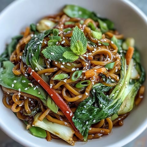 Fragrant ginger sauce glistens on Shirataki Noodle Bowl, garnished with green onions and sesame seeds.