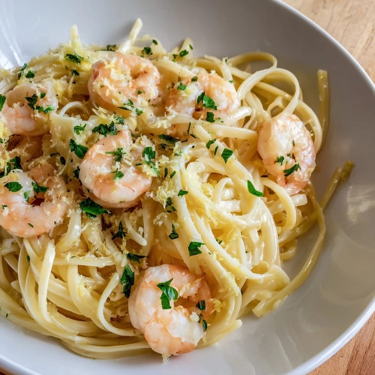 Overhead view of a freshly plated Garlic Butter Shrimp Linguine, ready to serve with a sprinkle of Parmesan cheese.