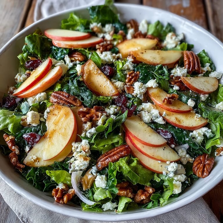 Sliced apples and toasted walnuts top a vibrant Mixed Greens and Apple Bowl for a crisp, refreshing lunch.