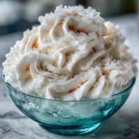 Fluffy and frosty TikTok Cloud Slushie in a clear glass, topped with a swirl of sweetened condensed milk.
