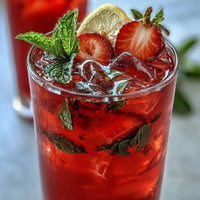 Juneteenth Red Drink: Vibrant hibiscus strawberry lemonade with fresh garnishes on ice.